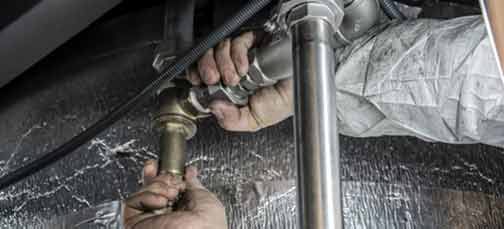 Plumber's hands checking your pipes is one of the best ways to remove bathroom odors