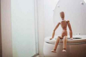 wooden-doll-resting-on-toilet