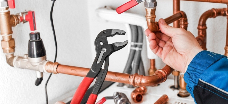 A plumber using tools to replace pipes.