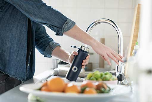 A person using a water faucet.