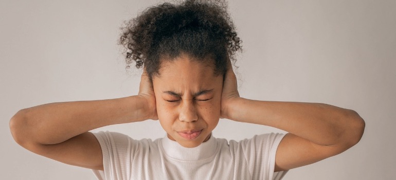 A person covering their ears in distress.