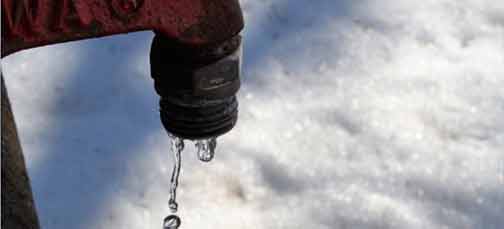 An outdoor faucet leaking in the winter.