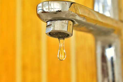 A close-up of water dripping out of a faucet