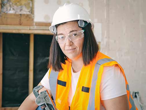 A female plumber holding a wrench