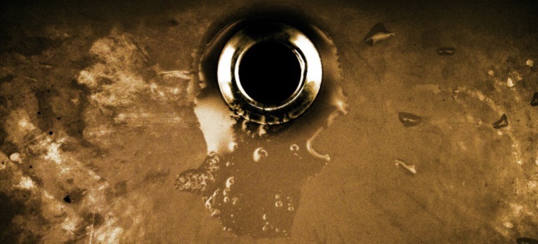 A drain in a kitchen sink.
