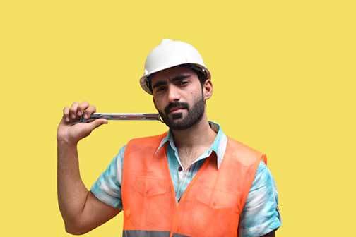 A person wearing a hard hat and holding a wrench