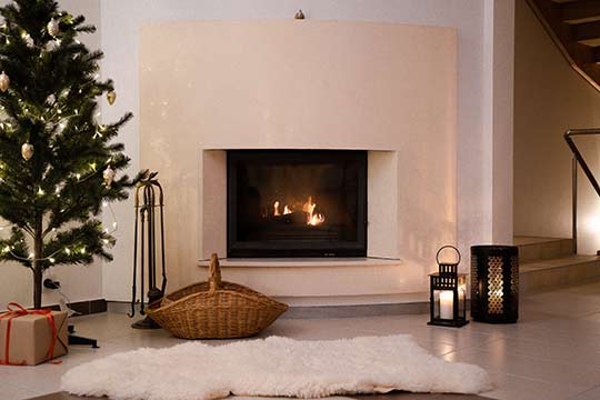 A warm fireplace with a roaring fire shows why preparing your home for the winter weather is important