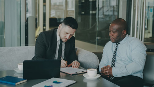 Two businessmen signing a document
