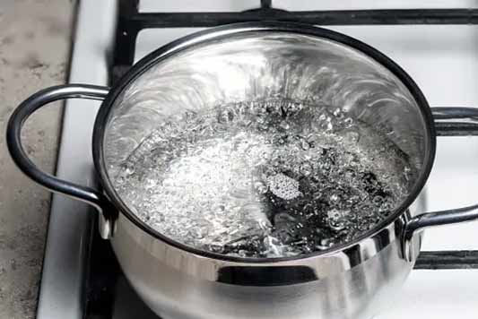 a pot of boiling water to be poured down the drain.