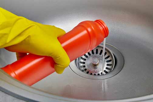 a person pouring chemical drain cleaner down their drain