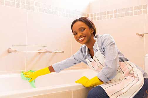 a woman cleaning her bathroom to rid of ant problem.