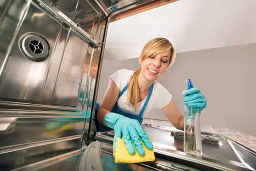 a woman cleaning her dishwasher.