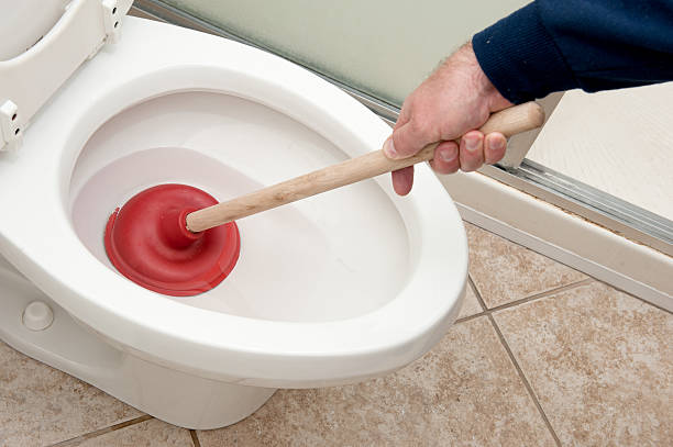 a man plunging a toilet.