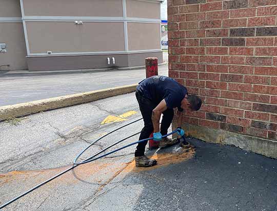a plumber performing a commercial drain cleaning.