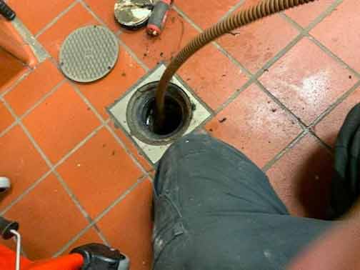 a commercial plumber performing a commercial drain cleaning.
