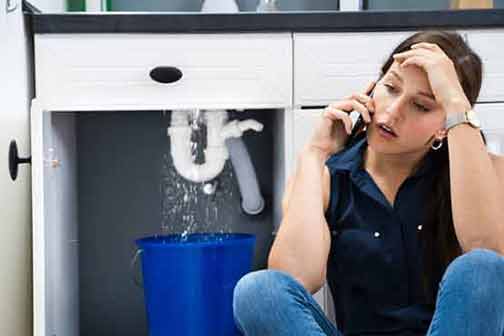 a woman calling a plumber for drain cleaning service.