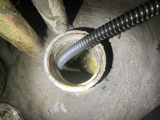 a drain cleaning service being performed