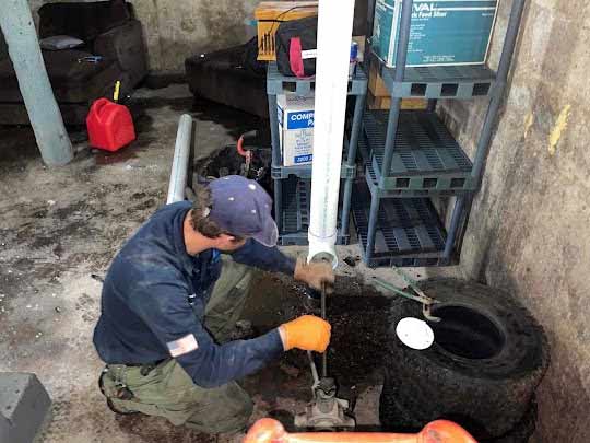 a plumber cleaning a back up sewer line