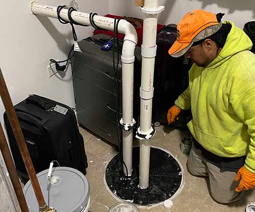 a plumber servicing a sewage ejector pump in chicago.