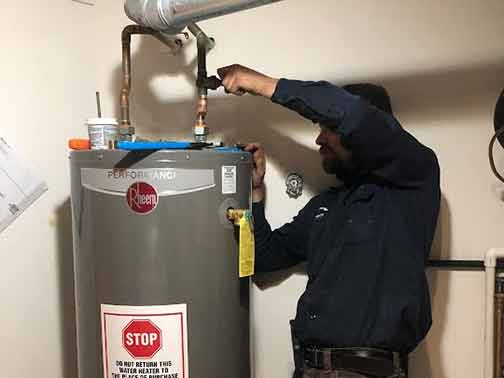 an emergency plumber performing a water heater repair.