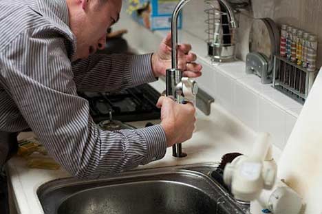 a man repairing a faucet