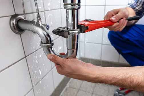 a plumber fixing leaking pipes.