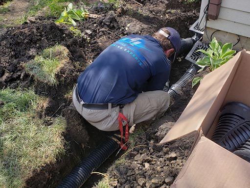 a professional installing a french drain system in illinois.