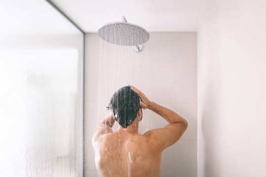 a man getting no hot water in the shower.