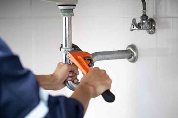 a plumber tightening loose plumbing fittings.