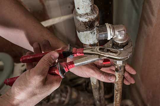 a plumber repairing older home plumbing.