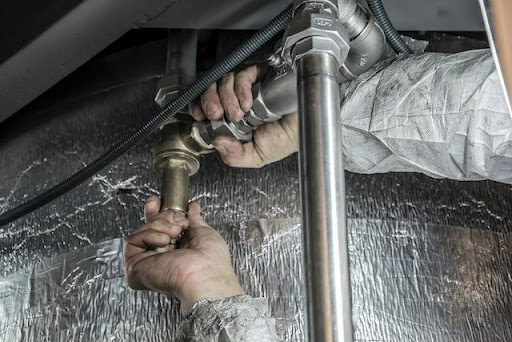 a plumber working on a pipe repair