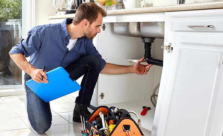 a plumber providing a home buyer with a plumbing inspection.