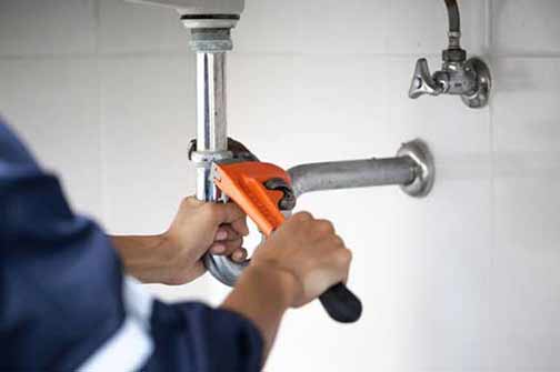 a professional plumber making repairs on plumbing.