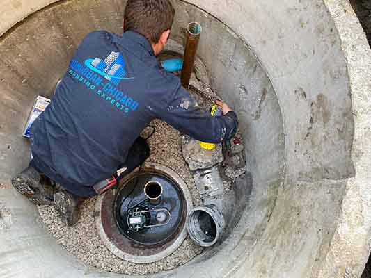 a plumber performing a sewage ejector pump replacement in chicago.