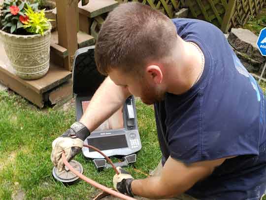 a professional plumber performing a sewer camera inspection.