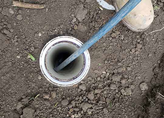 professional plumber working on a sewer line cleaning.