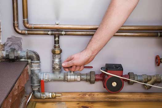 a man turning off his water supply in home.