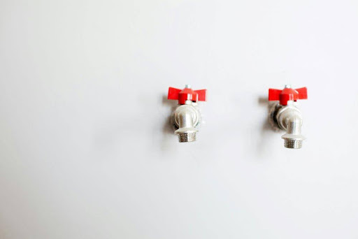 Two valves on the white wall.