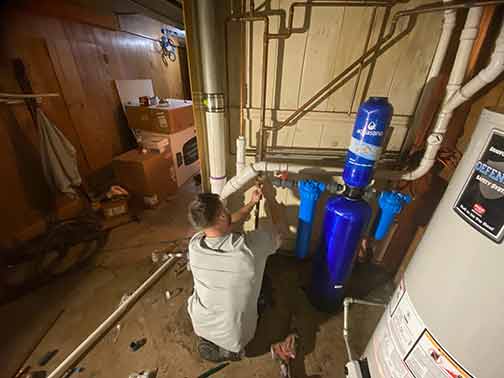 a plumber installing a water filtration system in a chicago home.