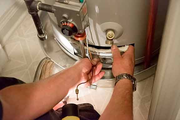 a person maintaining their water heater in chicago.
