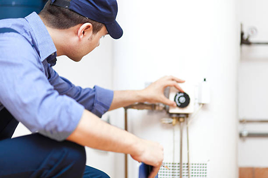 a plumber performing water heater maintenance.