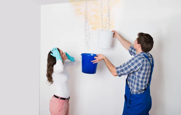 a couple repairing water stains on their wall.